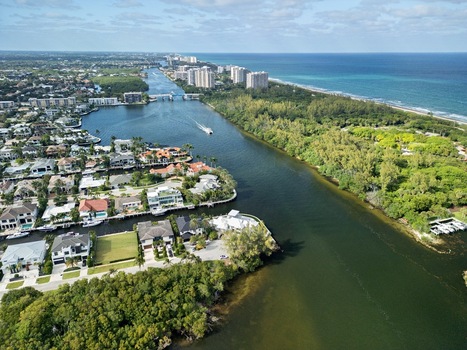 Aerial view of the Intracoastal Waterway with luxury waterfront homes dense tropical greenery and high rise buildings along the Atlantic coastline in Boca Raton Florida United States. Aerial view of the Intracoastal Waterway with luxury waterfront homes dense tropical greenery and high rise buildings along the Atlantic coastline in Boca Raton Florida United States.