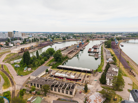 Aerial view of the industrial port area with barges cranes and dry docks along the Danube river under an overcast sky in Bratislava Bratislava Region Slovakia. Aerial view of the industrial port area with barges cranes and dry docks along the Danube river under an overcast sky in Bratislava Bratislava Region Slovakia.
