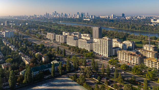 Aerial view of a modern residential area with apartment buildings and green spaces set against the Vistula River and Warsaw city skyline. Warsaw Masovian Voivodeship Poland.