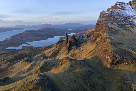 Aerial view of The Storr rock formation with rugged cliffs and Loch Leathan under a soft sky Isle of Skye Scotland United Kingdom. Aerial view of The Storr rock formation with rugged cliffs and Loch Leathan under a soft sky Isle of Skye Scotland United Kingdom.