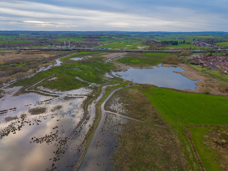 Aerial view of Doxey Marshes featuring expansive wetlands calm pools and lush green fields under a cloudy sky in Stafford England United Kingdom. Aerial view of Doxey Marshes featuring expansive wetlands calm pools and lush green fields under a cloudy sky in Stafford England United Kingdom.