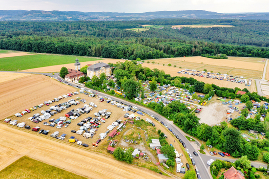 Aerial view of Schloss Jagersburg surrounded by lush trees a busy parking area and green agricultural fields in Eggolsheim Bayern Germany. Aerial view of Schloss Jagersburg surrounded by lush trees a busy parking area and green agricultural fields in Eggolsheim Bayern Germany.