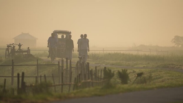 View of people walking on a misty road in Bogura Bangladesh.