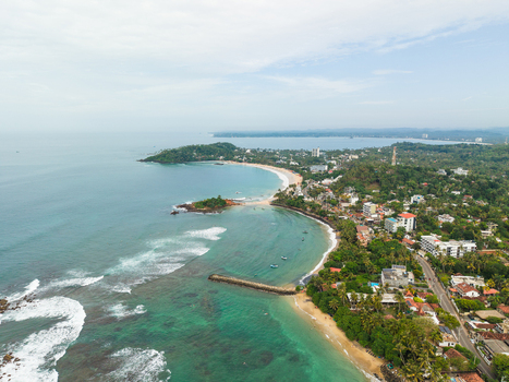 Aerial view of Parrot Rock and the scenic coastline with turquoise ocean waves sandy beaches and lush tropical greenery in Mirissa Southern Province Sri Lanka. Aerial view of Parrot Rock and the scenic coastline with turquoise ocean waves sandy beaches and lush tropical greenery in Mirissa Southern Province Sri Lanka.