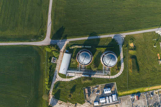 Aerial view of the UGS Damborice industrial facility with two large storage tanks and service buildings surrounded by green fields in Damborice South Moravian Region Czechia. Aerial view of the UGS Damborice industrial facility with two large storage tanks and service buildings surrounded by green fields in Damborice South Moravian Region Czechia.