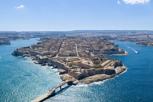 Aerial view of the historic city of Valletta featuring the fortified peninsula Fort Saint Elmo and the surrounding Grand Harbour under a clear blue sky in Valletta Port Region Malta. Aerial view of the historic city of Valletta featuring the fortified peninsula Fort Saint Elmo and the surrounding Grand Harbour under a clear blue sky in Valletta Port Region Malta.