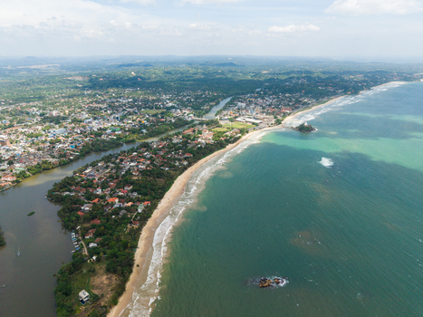Aerial view of the Nilwala River flowing into the Indian Ocean alongside the sandy coastline and the Parevi Duwa temple in Matara Southern Province Sri Lanka. Aerial view of the Nilwala River flowing into the Indian Ocean alongside the sandy coastline and the Parevi Duwa temple in Matara Southern Province Sri Lanka.