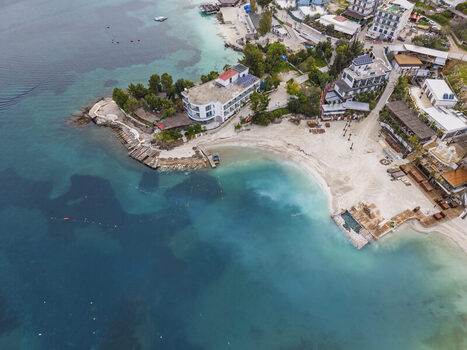 Aerial view of the coastal town of Ksamil with its turquoise waters sandy beaches and hotels along the shoreline in Ksamil Vlore County Albania. Aerial view of the coastal town of Ksamil with its turquoise waters sandy beaches and hotels along the shoreline in Ksamil Vlore County Albania.