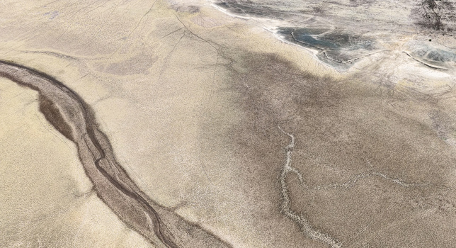 Aerial view of a completely dry riverbed with cracked earth and parched channels cutting through the arid landscape highlighting severe drought in Bloemhof North West South Africa. Aerial view of a completely dry riverbed with cracked earth and parched channels cutting through the arid landscape highlighting severe drought in Bloemhof North West South Africa.