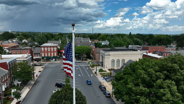 Aerial view of the town of Manheim with an American flag flying over the street surrounded by historic brick buildings trees and cars on the road in Manheim Pennsylvania United States.