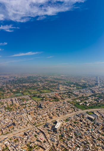 Aerial view of Bala Hisar Fort surrounded by the dense urban landscape and historic streets of Peshawar under a clear blue sky in Peshawar Khyber Pakhtunkhwa Pakistan.