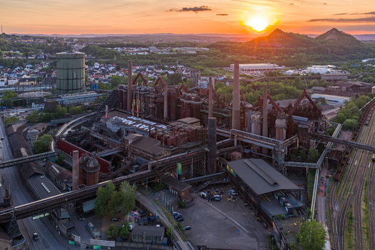 Volklingen Germany 09 May 2026 Aerial view of the Volklingen Ironworks industrial complex with blast furnaces and chimneys under a golden sunset sky. Volklingen Germany 09 May 2026 Aerial view of the Volklingen Ironworks industrial complex with blast furnaces and chimneys under a golden sunset sky.