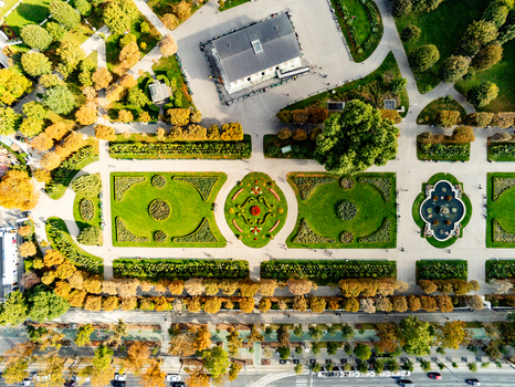 Aerial view of the formal gardens at Belvedere Palace with manicured lawns geometric flower beds a central fountain and surrounding autumn trees in Vienna Vienna Austria.