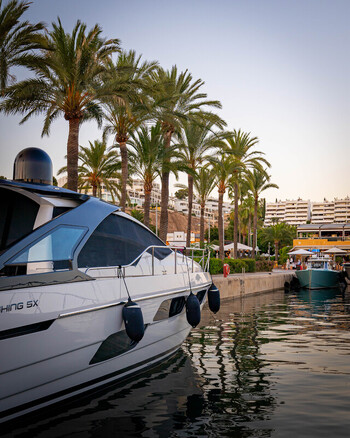 Balearic Islands Spain 15 September 2023 View of a luxury yacht docked in a marina in Mallorca lined with tall palm trees and white buildings under a clear sky. Balearic Islands Spain 15 September 2023 View of a luxury yacht docked in a marina in Mallorca lined with tall palm trees and white buildings under a clear sky.