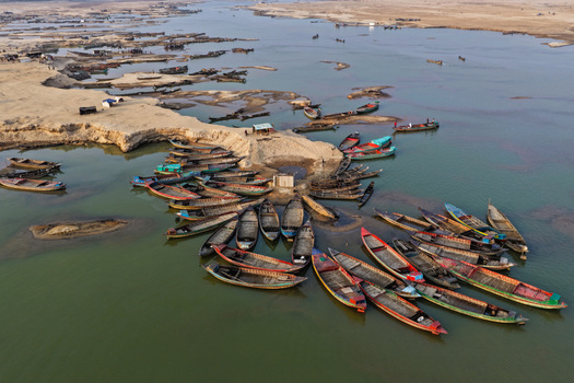 Aerial view of Jadukata River with numerous traditional wooden boats moored along the sandy banks in Sunamganj Sylhet Division Bangladesh. Aerial view of Jadukata River with numerous traditional wooden boats moored along the sandy banks in Sunamganj Sylhet Division Bangladesh.