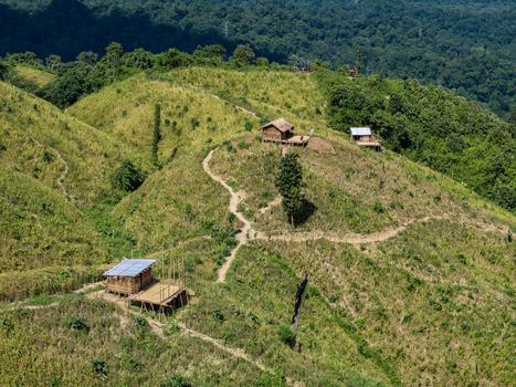 Aerial view of Shita Pahar featuring small wooden huts on grassy hills with winding dirt paths and dense forest in Kaptai Chittagong Division Bangladesh. Aerial view of Shita Pahar featuring small wooden huts on grassy hills with winding dirt paths and dense forest in Kaptai Chittagong Division Bangladesh.