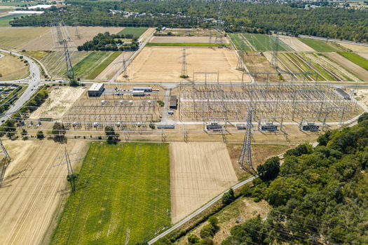 Aerial view of the Amprion Umspannwerk electrical substation surrounded by agricultural fields and power transmission lines in Pfungstadt Hessen Germany.