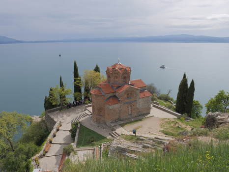View of the Church of St. John at Kaneo overlooking Lake Ohrid with cypress trees and stone architecture in Ohrid Municipality of Ohrid North Macedonia. View of the Church of St. John at Kaneo overlooking Lake Ohrid with cypress trees and stone architecture in Ohrid Municipality of Ohrid North Macedonia.