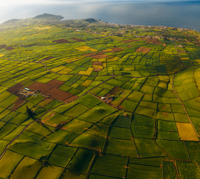 Aerial view of the lush agricultural patchwork of Pico Dona Joana volcanic cone and surrounding green fields under soft sunlight Feteira Acores Portugal. Aerial view of the lush agricultural patchwork of Pico Dona Joana volcanic cone and surrounding green fields under soft sunlight Feteira Acores Portugal.