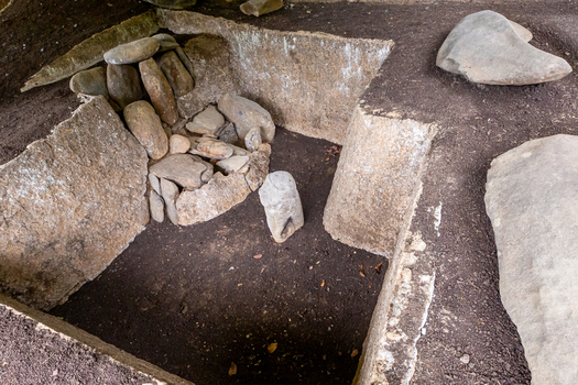 View of the ancient stone burial chamber at San Agustin Archaeological Park with carved stone figures and megalithic slabs in San Agustin Huila Colombia.
