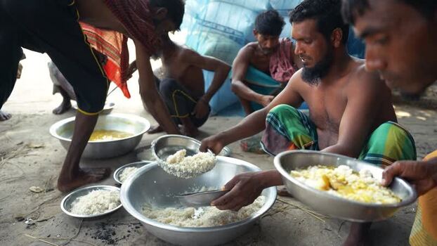 View of men serving rice during a communal meal in Bangladesh. View of men serving rice during a communal meal in Bangladesh.