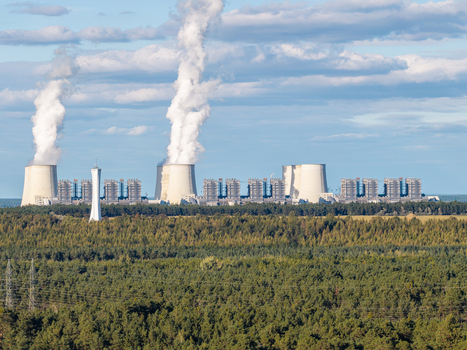 Aerial view of the Janschwalde Power Station with cooling towers emitting steam surrounded by dense pine forests under a blue sky in Peitz Brandenburg Germany. Aerial view of the Janschwalde Power Station with cooling towers emitting steam surrounded by dense pine forests under a blue sky in Peitz Brandenburg Germany.