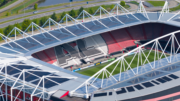 Alkmaar Netherlands 05 May 2026 Aerial view of AFAS stadium featuring its modern roof structure with solar panels and red seating stands under bright daylight.