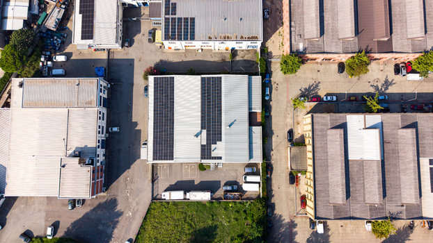 Aerial view of an industrial zone featuring warehouses with solar panels on rooftops parking areas and surrounding roads in Milan Lombardy Italy. Aerial view of an industrial zone featuring warehouses with solar panels on rooftops parking areas and surrounding roads in Milan Lombardy Italy.