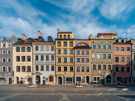 View of the colorful historic townhouses and the Muzeum Warszawy in the Warsaw Old Town square under a clear blue sky in Warsaw Masovian Voivodeship Poland. View of the colorful historic townhouses and the Muzeum Warszawy in the Warsaw Old Town square under a clear blue sky in Warsaw Masovian Voivodeship Poland.