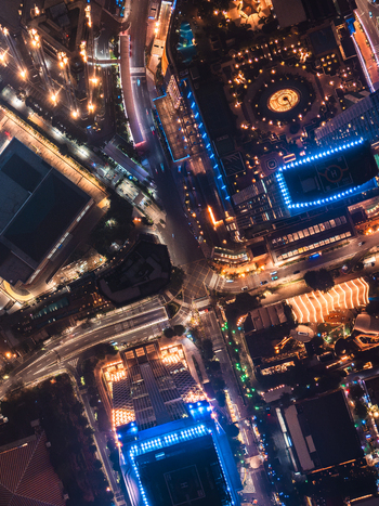 Aerial view of illuminated skyscrapers and busy city streets at night in Jakarta Indonesia.