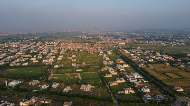 Aerial view of residential neighborhoods green spaces and urban infrastructure in the outskirts of Lahore Punjab Pakistan.