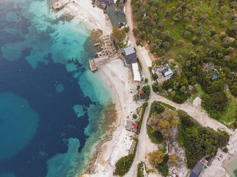 Aerial view of the turquoise waters and sandy coastline of Ksamil with nearby roads and lush greenery in Ksamil Vlore County Albania. Aerial view of the turquoise waters and sandy coastline of Ksamil with nearby roads and lush greenery in Ksamil Vlore County Albania.