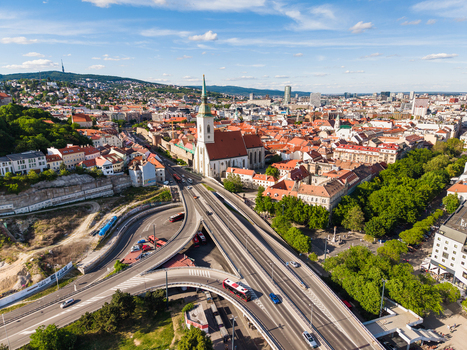 Aerial view of St. Martin s Cathedral and the historic old town with a busy road interchange and lush green trees under a blue sky in Bratislava Bratislava Region Slovakia. Aerial view of St. Martin s Cathedral and the historic old town with a busy road interchange and lush green trees under a blue sky in Bratislava Bratislava Region Slovakia.