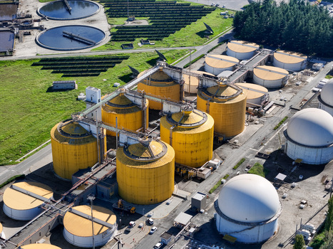 Aerial view of the Impianto depurazione water treatment plant featuring large yellow tanks solar panels and circular basins in Castiglione Torinese Piedmont Italy.