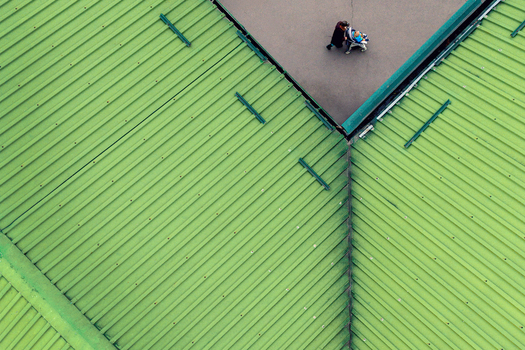 Aerial view of a person walking on a paved area adjacent to a bright green corrugated metal roof in Belgrade City of Belgrade Serbia. Aerial view of a person walking on a paved area adjacent to a bright green corrugated metal roof in Belgrade City of Belgrade Serbia.