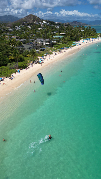 Aerial view of the turquoise ocean meeting the pristine white sands of Lanikai Beach under a sky brushed with clouds Kailua Hawaii United States. Aerial view of the turquoise ocean meeting the pristine white sands of Lanikai Beach under a sky brushed with clouds Kailua Hawaii United States.