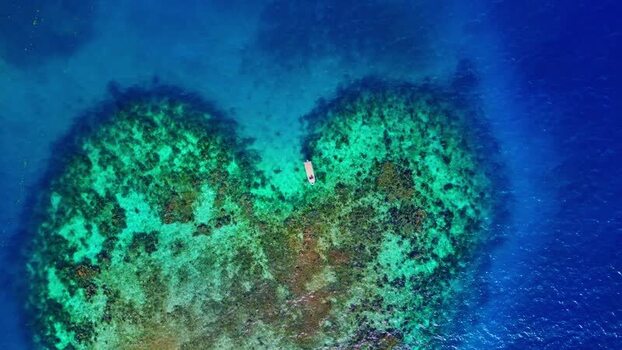 Aerial view of a heart shaped coral reef and a boat Honduras. Aerial view of a heart shaped coral reef and a boat Honduras.