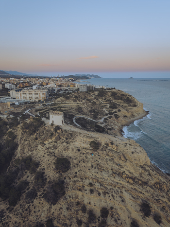 Aerial view of the Santuari iber i roma de la Malladeta on a rugged cliff overlooking the Mediterranean Sea at sunset in La Vila Joiosa Comunidad Valenciana Spain. Aerial view of the Santuari iber i roma de la Malladeta on a rugged cliff overlooking the Mediterranean Sea at sunset in La Vila Joiosa Comunidad Valenciana Spain.