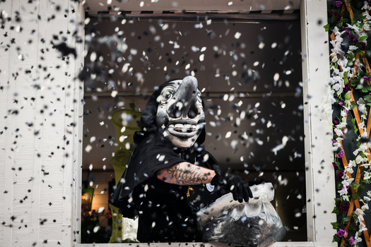 Basel Switzerland 10 March 2025 View of a masked figure in black framed by a window amidst a flurry of confetti during Fasnacht celebrations. Basel Switzerland 10 March 2025 View of a masked figure in black framed by a window amidst a flurry of confetti during Fasnacht celebrations.