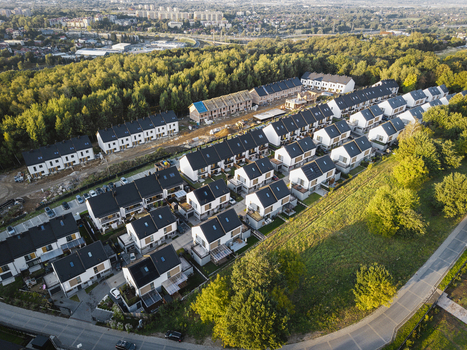 Aerial view of modern row houses in a new residential development surrounded by green trees and roads in Wieliczka Lesser Poland Voivodeship Poland.