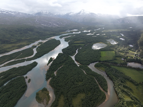 Aerial view of the braided river system with lush green river islands and glacial meltwater channels flowing through the valley near Skonseng Nordland Norway. Aerial view of the braided river system with lush green river islands and glacial meltwater channels flowing through the valley near Skonseng Nordland Norway.