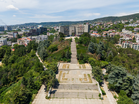 Aerial view of the Monument of the Bulgarian Soviet Friendship a massive concrete structure on a hill with stairs trees and urban buildings in Varna Varna Bulgaria.