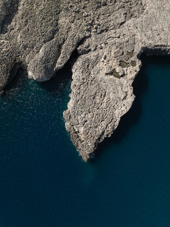 Aerial view of the jagged limestone cliffs and deep blue waters of the Plemmirio Marine Protected Area Plemmirio Sicily Italy. Aerial view of the jagged limestone cliffs and deep blue waters of the Plemmirio Marine Protected Area Plemmirio Sicily Italy.