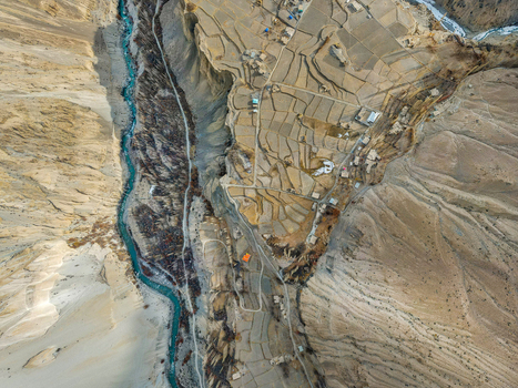 Aerial view of the turquoise river snaking through the rugged arid landscape alongside the terraced fields Hunza Nagar Gilgit Pakistan. Aerial view of the turquoise river snaking through the rugged arid landscape alongside the terraced fields Hunza Nagar Gilgit Pakistan.