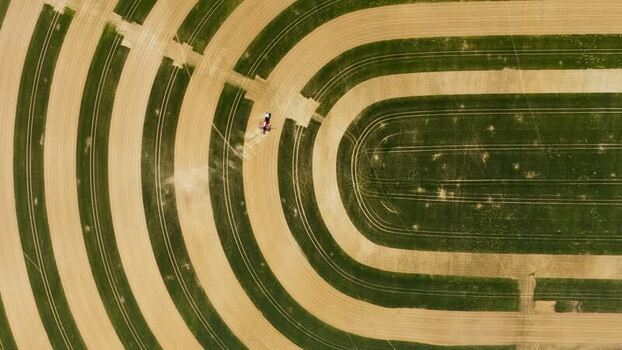 Aerial view of a tractor working in a striped field Czechia. Aerial view of a tractor working in a striped field Czechia.