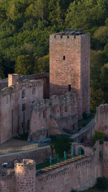 Aerial view of the historic Henneburg castle ruins with its prominent red sandstone tower stone walls and surrounding lush forest in Stadtprozelten Bayern Germany. Aerial view of the historic Henneburg castle ruins with its prominent red sandstone tower stone walls and surrounding lush forest in Stadtprozelten Bayern Germany.