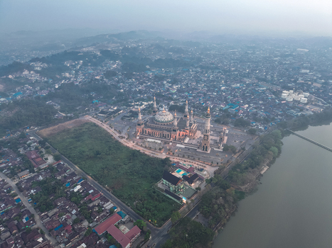 Aerial view of the Baitul Muttaqien Mosque the East Kalimantan Islamic Center with its prominent domes and minarets near the river in Samarinda East Kalimantan Indonesia.