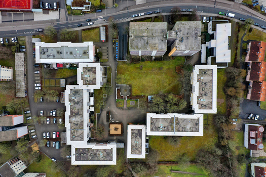 Aerial view of a residential apartment complex with flat rooftops green courtyards and parking lots in Forchheim Bavaria Germany.