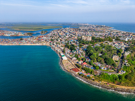 Aerial view of the coastal skyline and urban landscape with dense buildings and lush greenery along the Atlantic Ocean in Monrovia Montserrado Liberia. Aerial view of the coastal skyline and urban landscape with dense buildings and lush greenery along the Atlantic Ocean in Monrovia Montserrado Liberia.