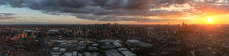 Aerial view of the London skyline at sunset featuring the River Thames Canary Wharf and the O2 Arena under dramatic clouds in London Greater London United Kingdom.